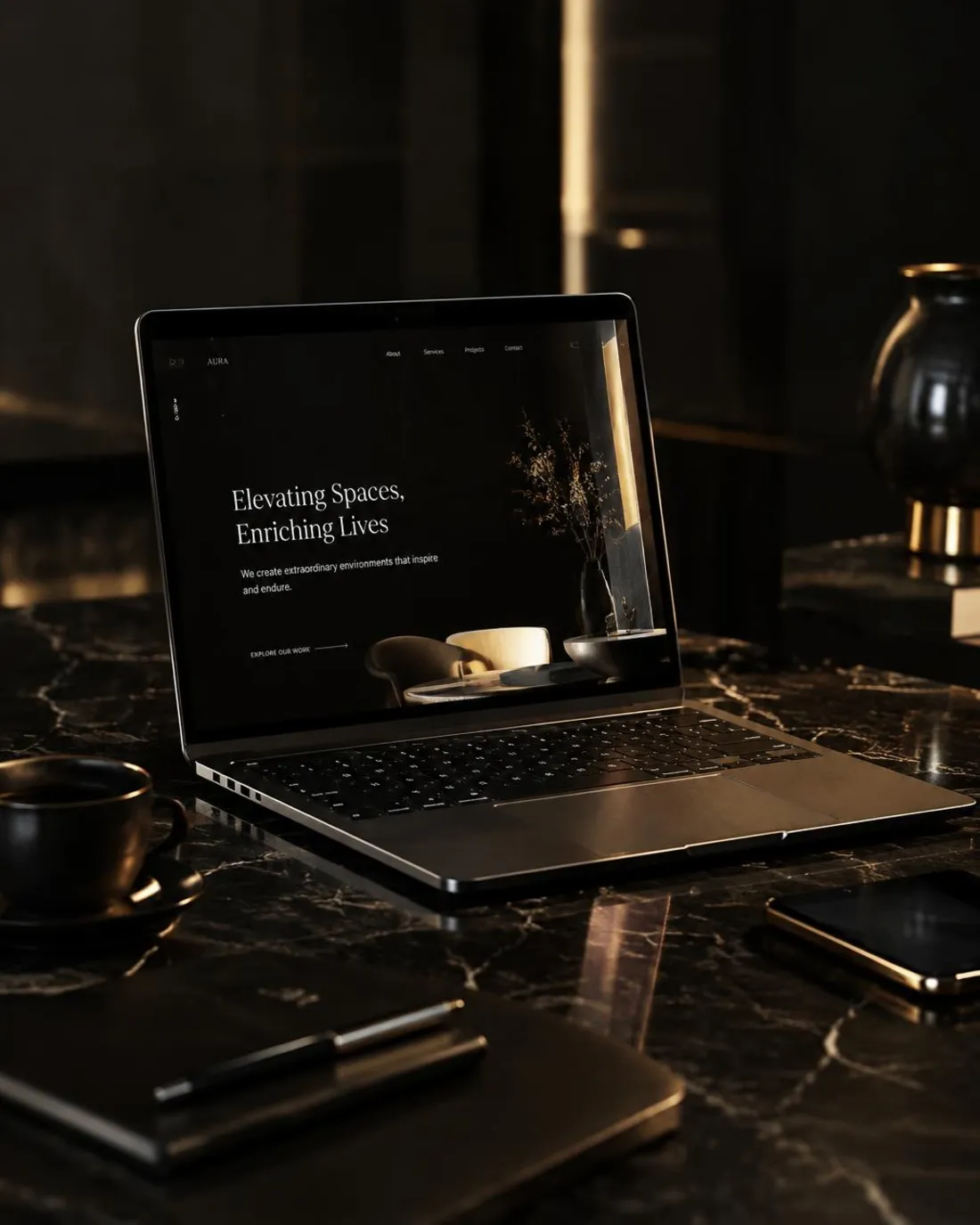 A laptop on a black marble desk displaying an elegant dark website